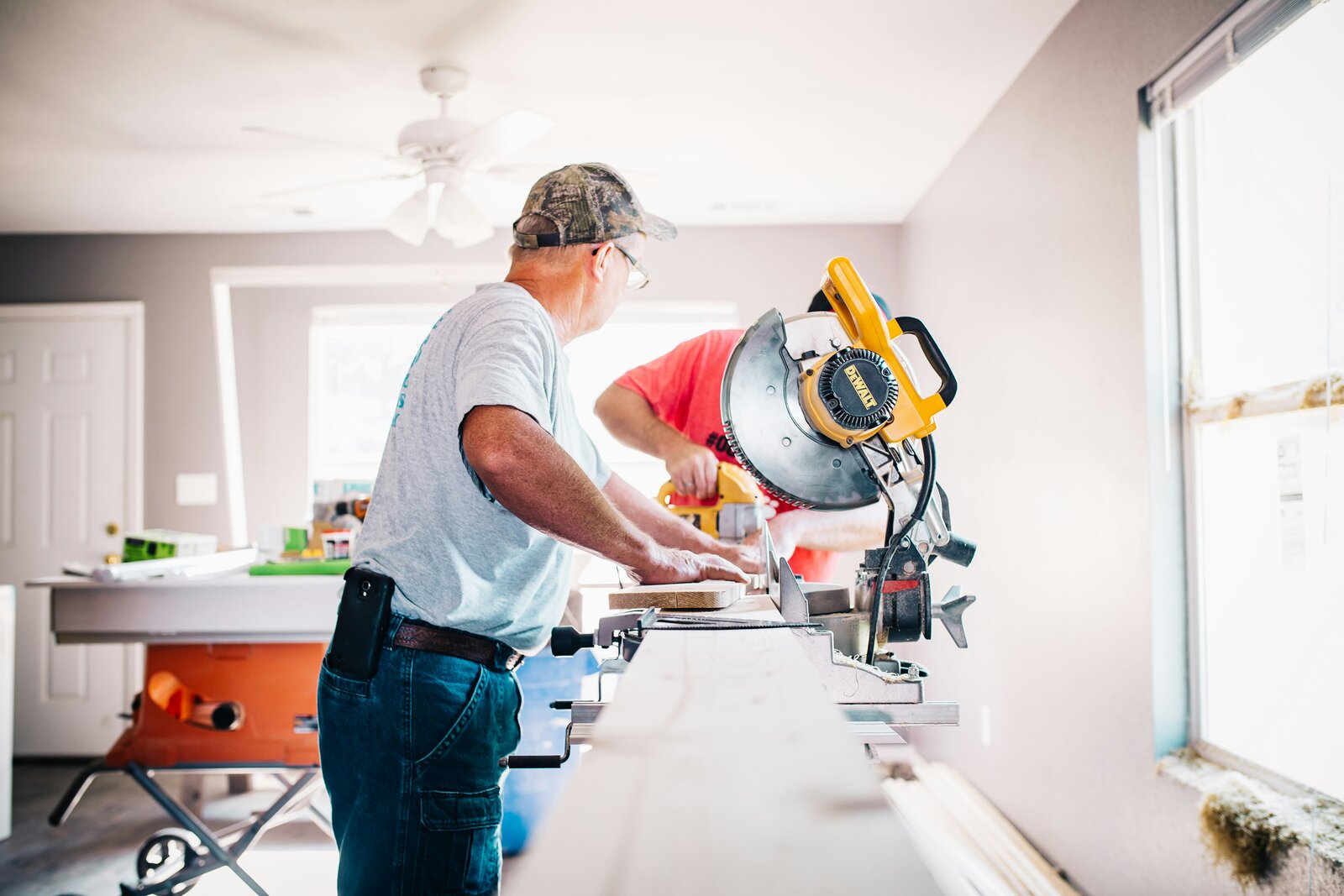 Homeowner reviewing building permit paperwork at a desk with architectural plans