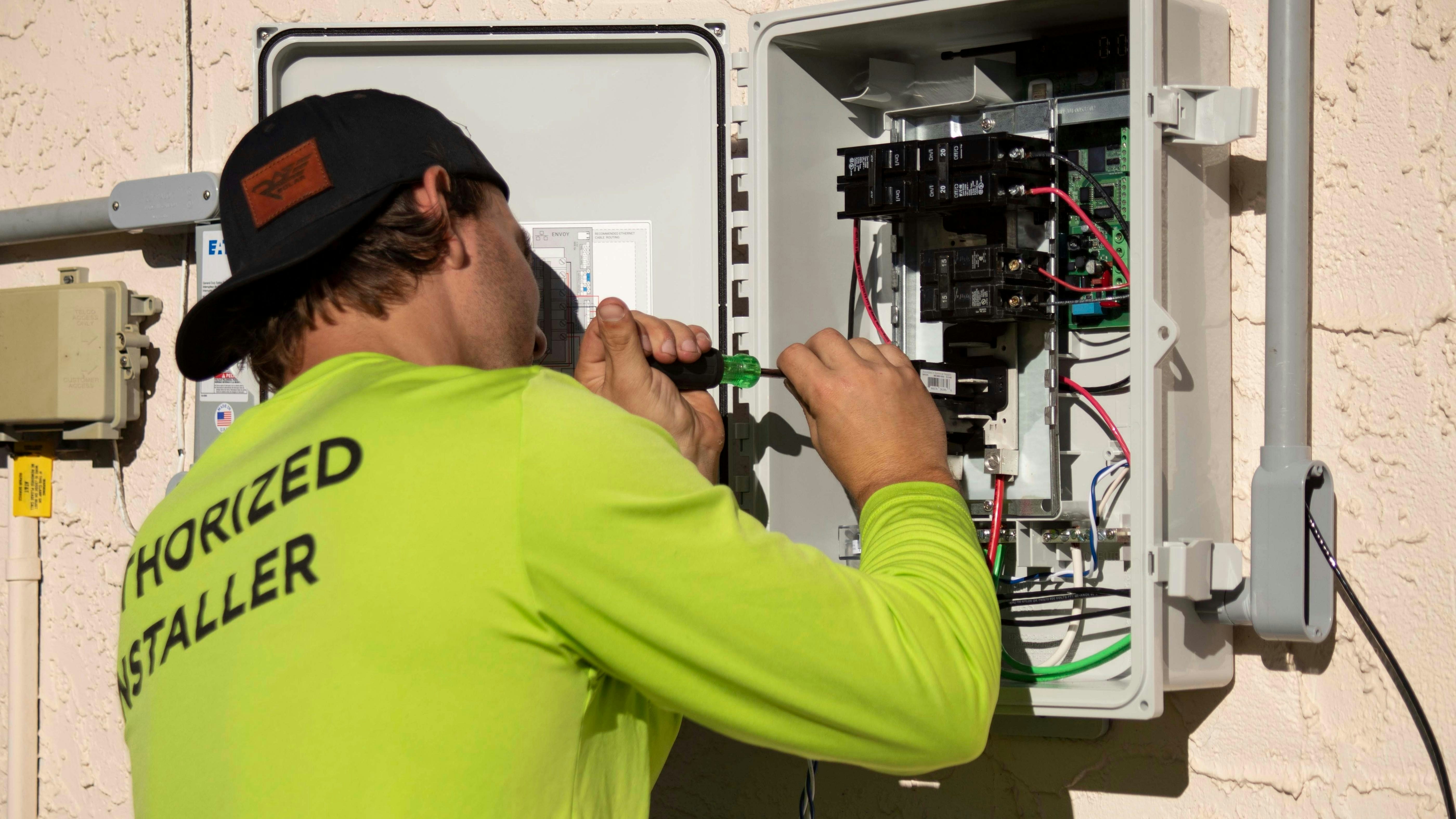 Licensed electrician working on an outdoor electrical panel