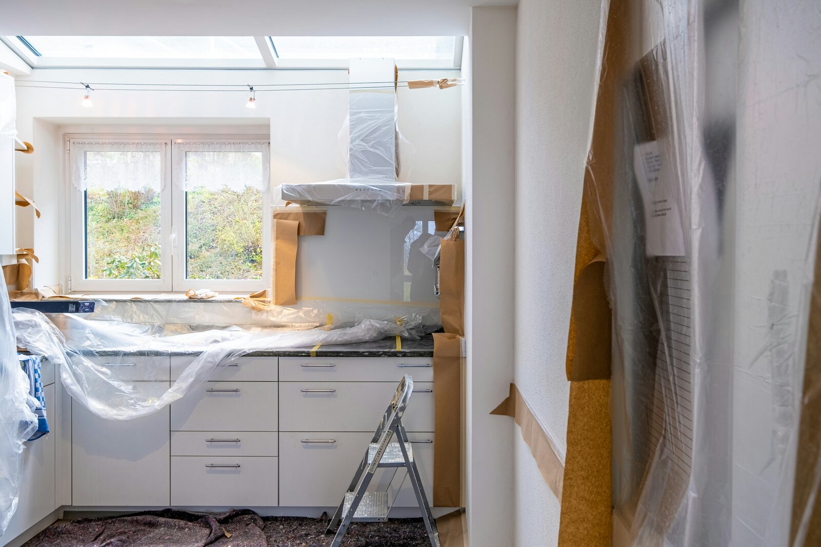 San Francisco kitchen mid-remodel with exposed cabinets and permit paperwork on the counter