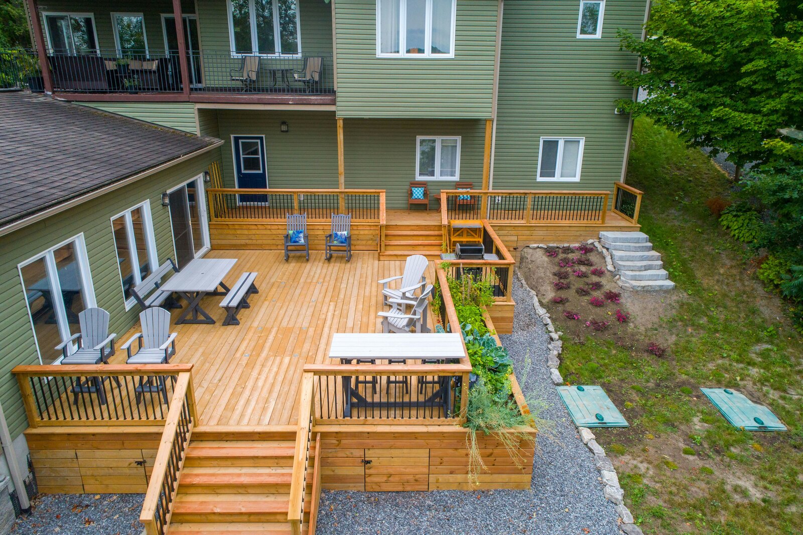 Wooden deck with outdoor chairs and tables next to a home